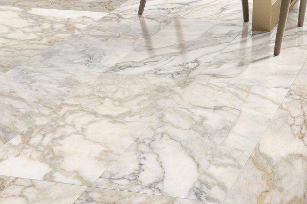 Marble tile flooring with swirling beige, white, and gray patterns.