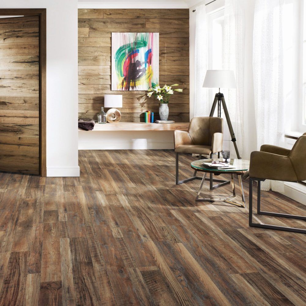 Wood-paneled room with wooden floor, two chairs, table, and artwork on the wall.