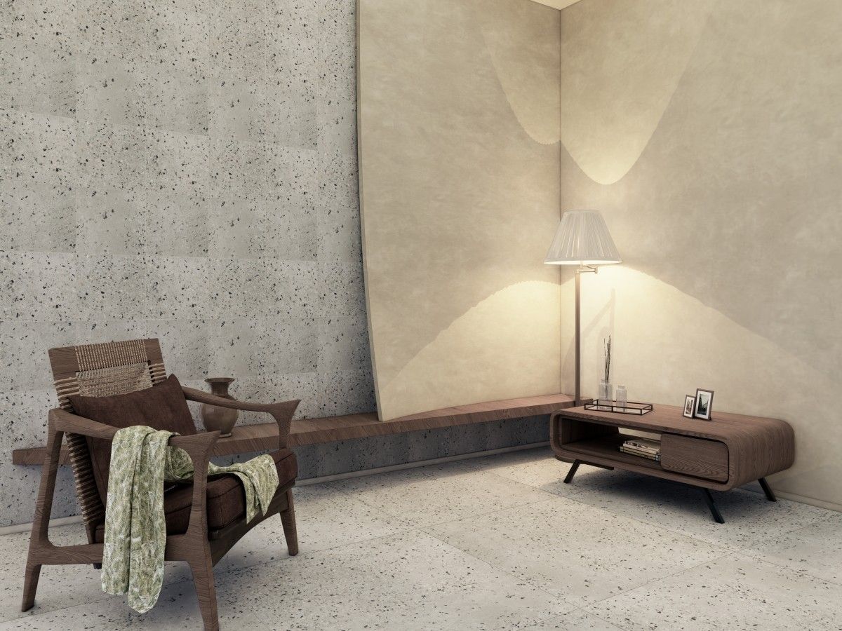 Cozy living room corner with a wooden armchair, throw, lamp, and cabinet. Stone wall and floor.