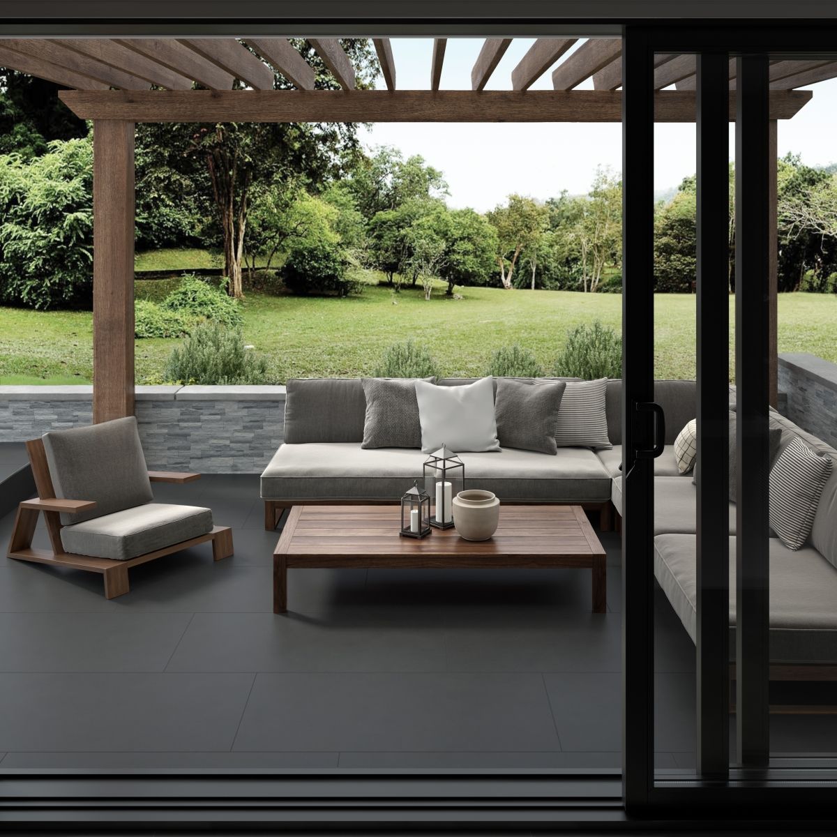 Patio with outdoor furniture under a pergola overlooking a grassy yard; dark gray floor and sliding glass door.