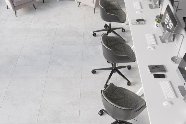 Office workspace with three rolling chairs lined up, desks, and computers.
