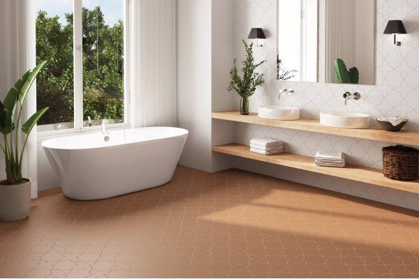 Modern bathroom with white tub, double sinks, and wood-toned hexagon tile flooring.
