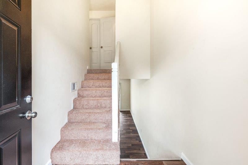 A hallway with stairs leading up to the second floor of a house.