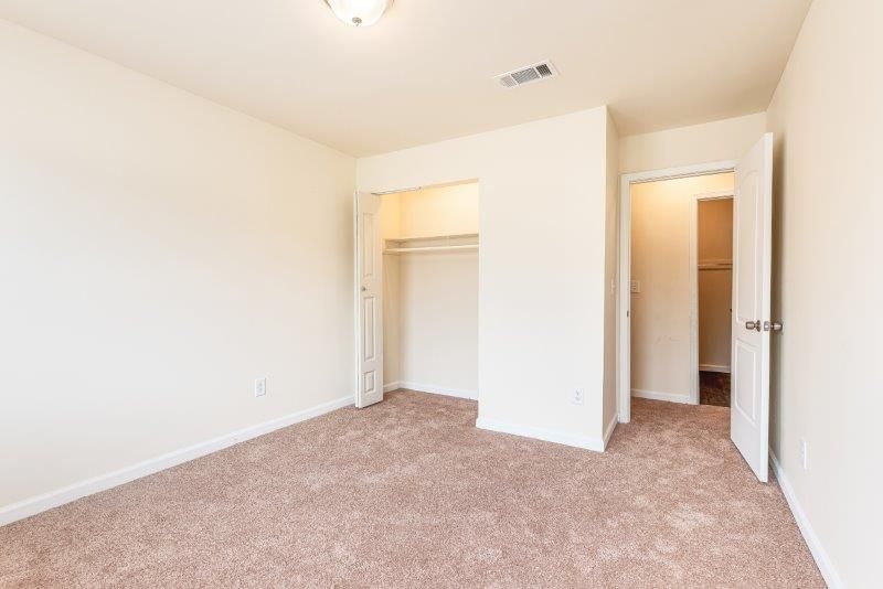 An empty bedroom with a closet and a walk in closet.