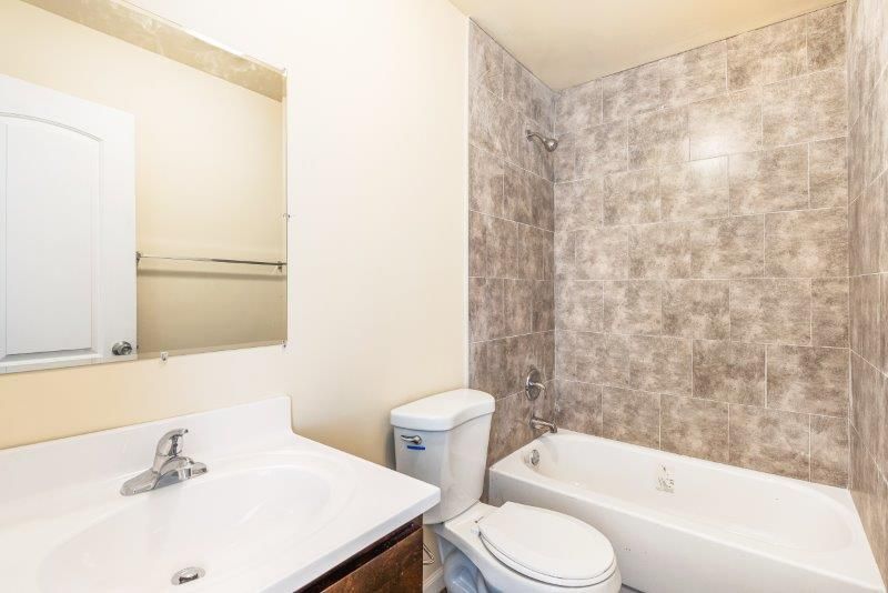 A bathroom with a toilet , sink , and bathtub.