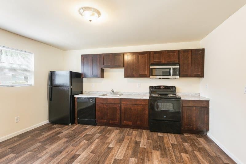 A kitchen with a refrigerator , stove , dishwasher , and microwave.
