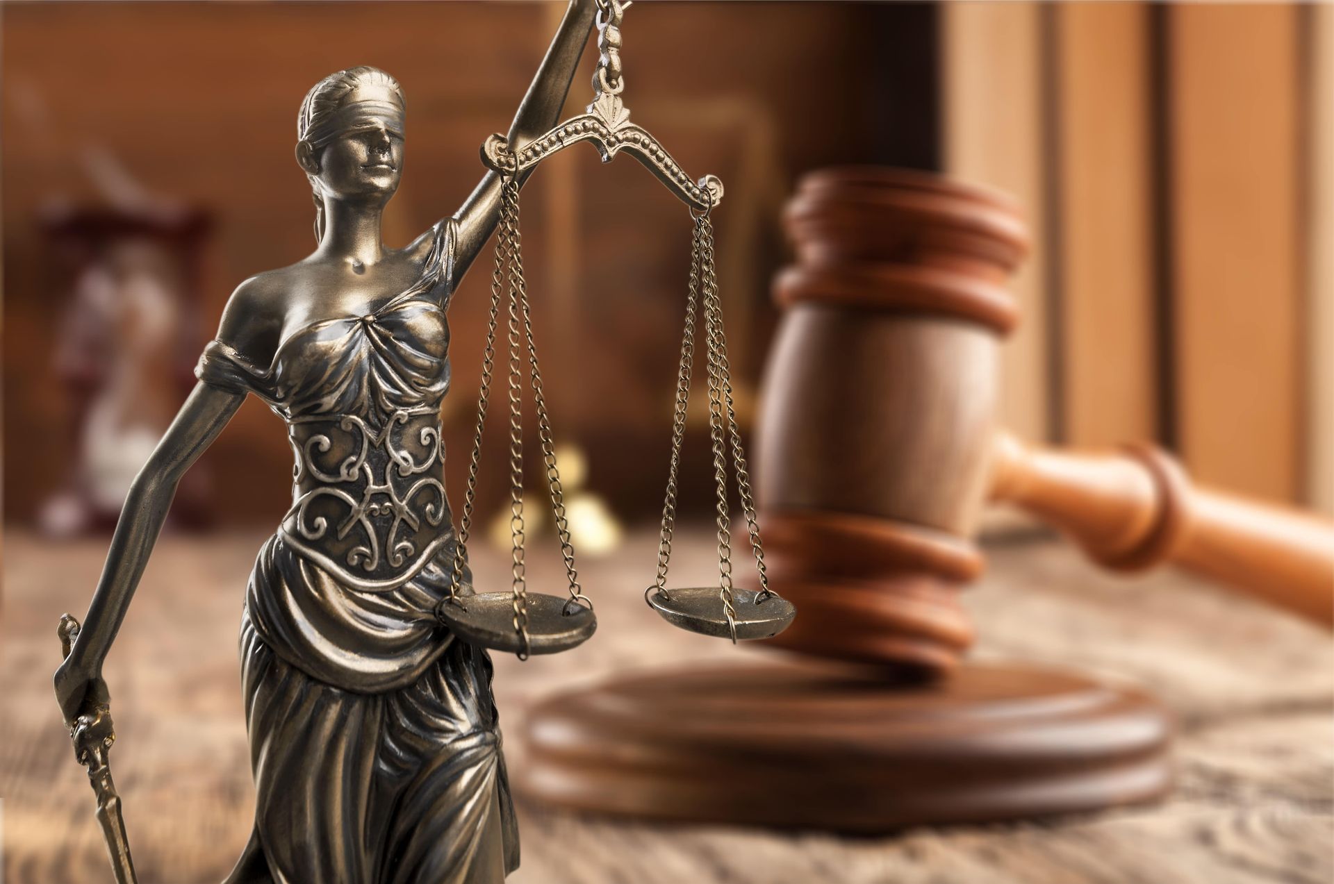 Lady Justice statue with scales, and a wooden gavel.