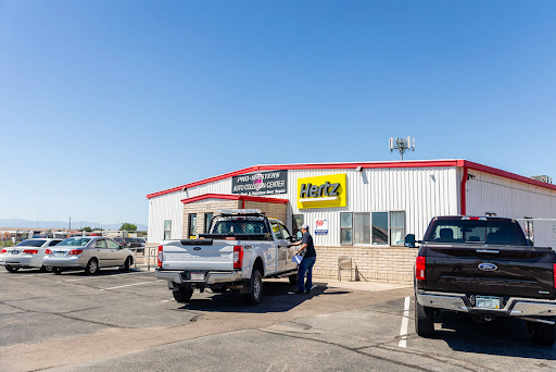 A couple of trucks are parked in front of a building.
