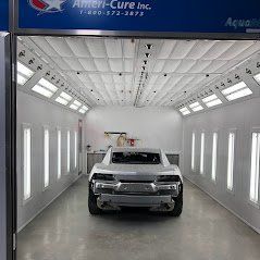 A car is sitting inside of a paint booth.