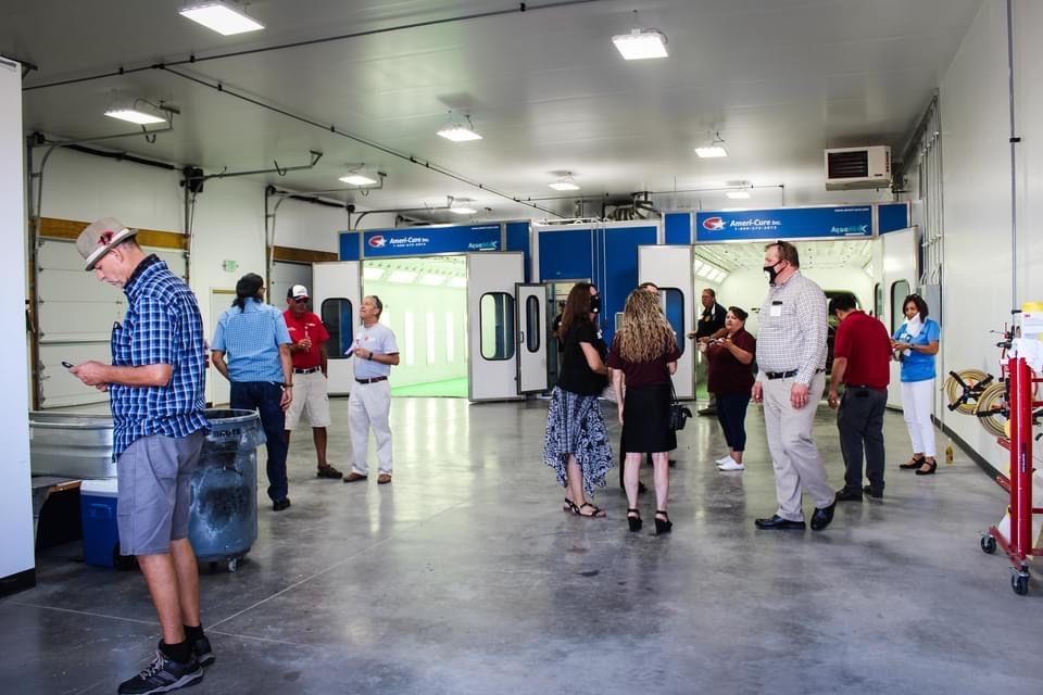 A group of people are standing in a room talking to each other.