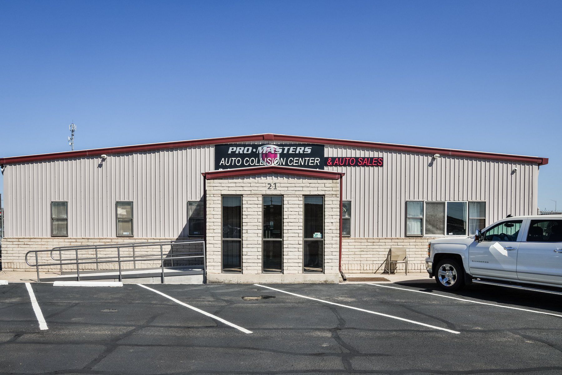 A white truck is parked in front of a building.