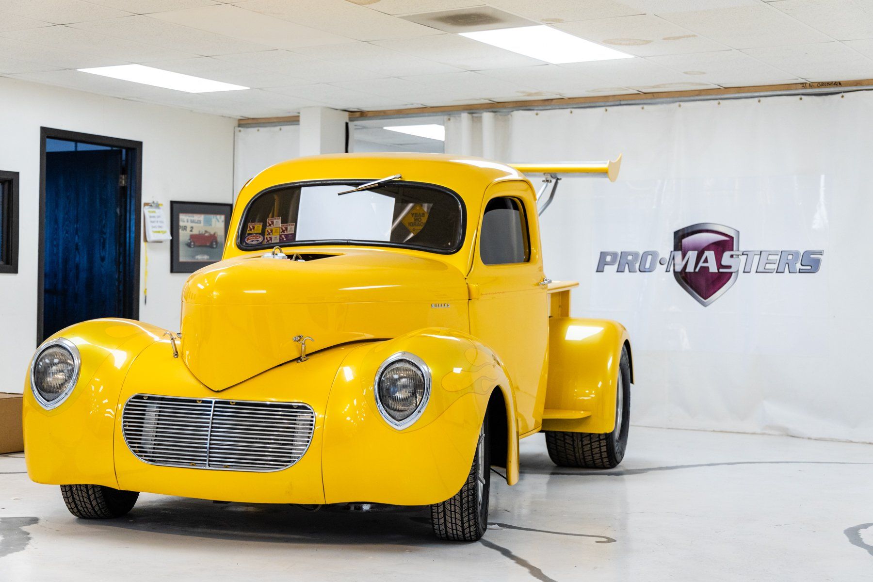 A yellow truck is parked in a garage.