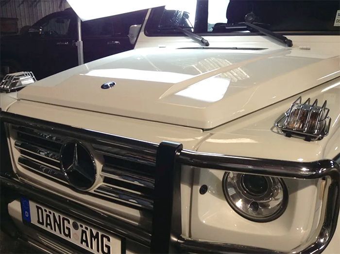A white mercedes with a license plate that says dang amg