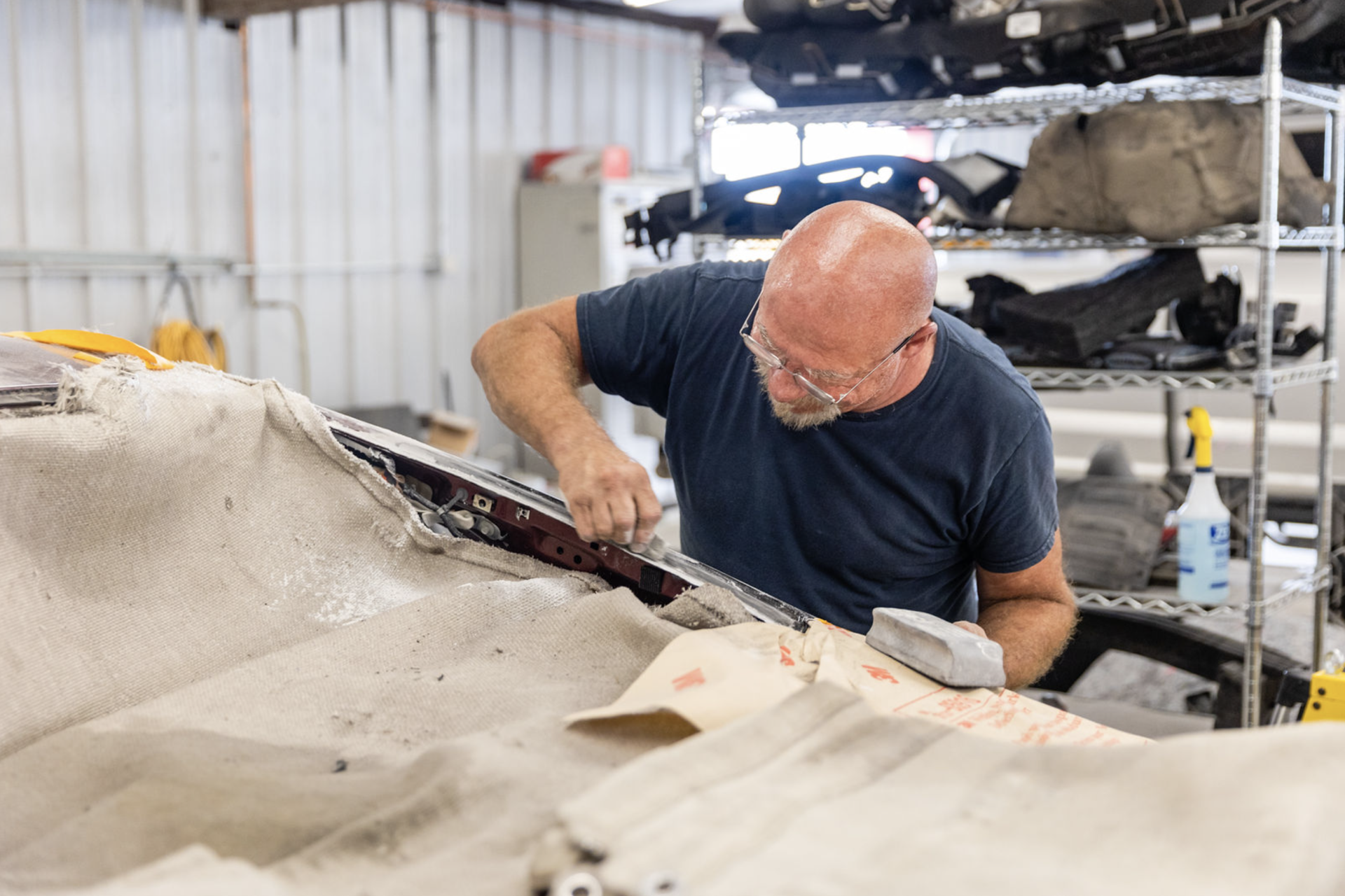 A man is working on a car in a garage.