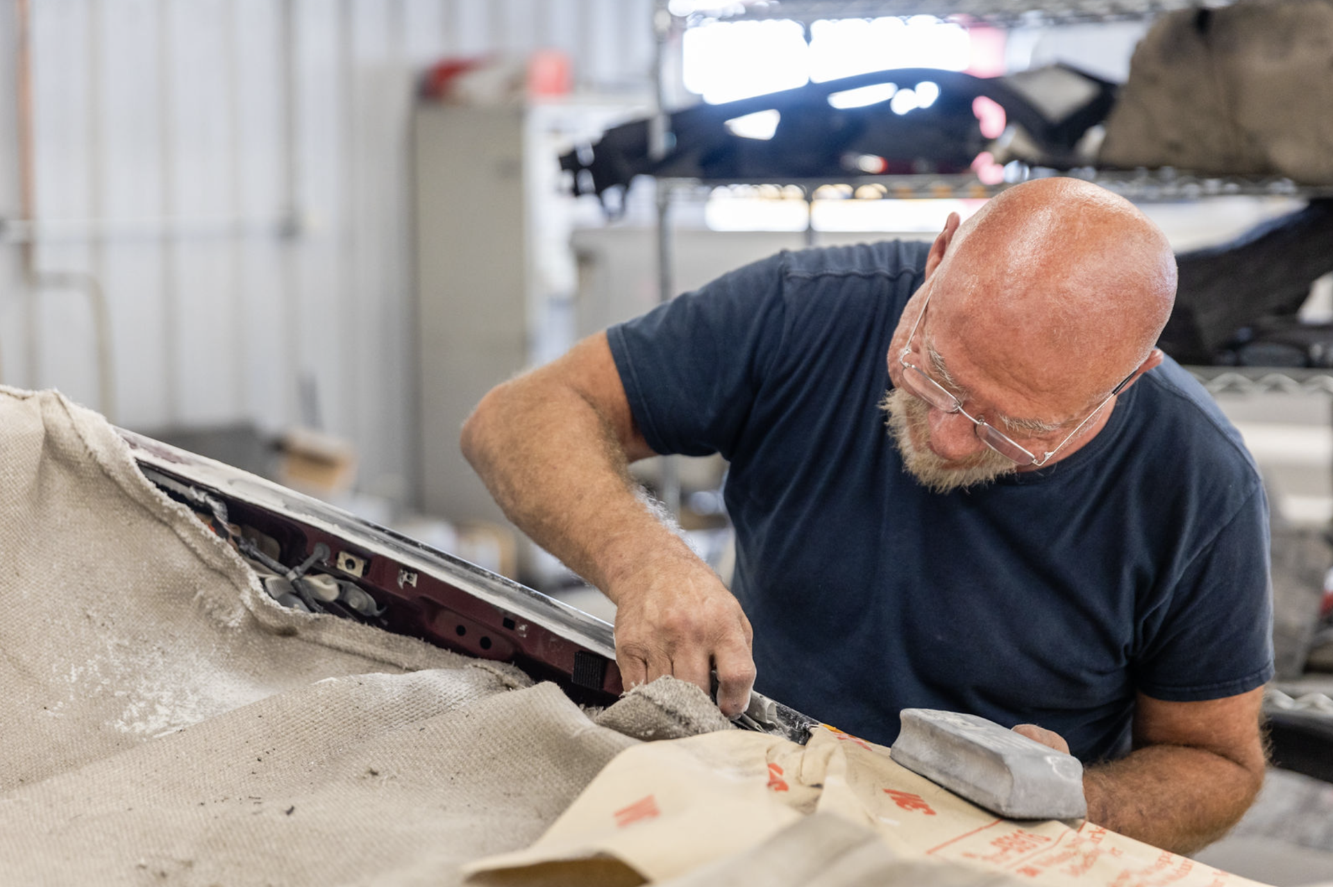 A man is working on a car in a garage.