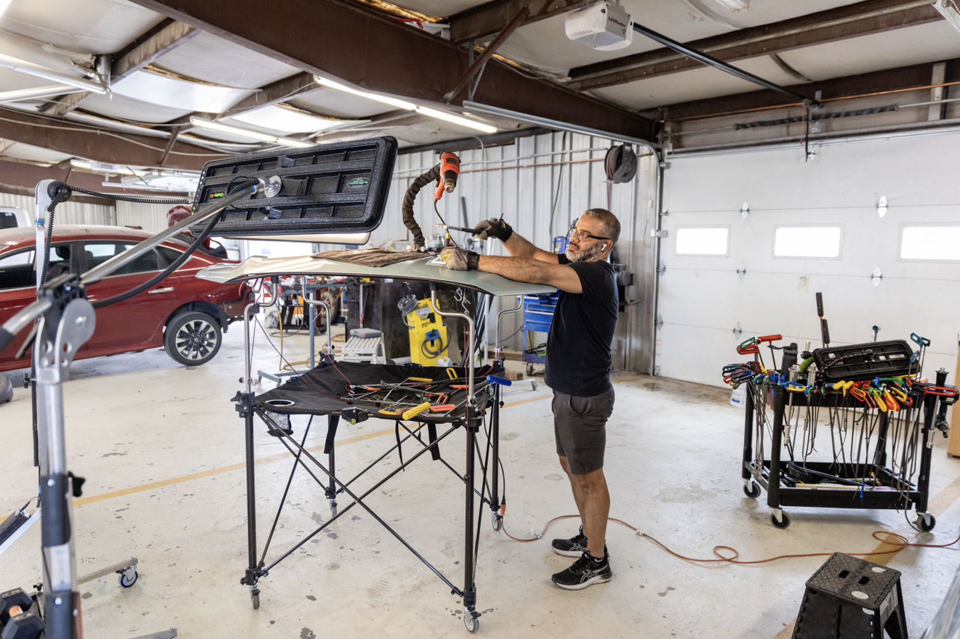 A man is working on a car in a garage.