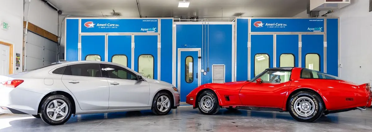 A white car and a red car are parked next to each other in a garage.