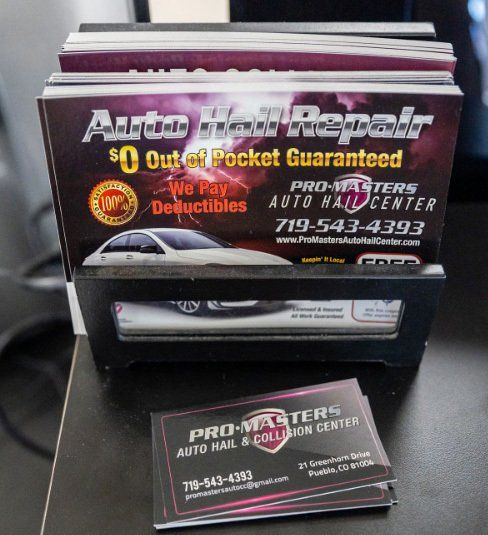 A stack of business cards for auto hail repair