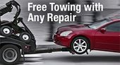 A red car is being towed by a tow truck.