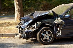 A damaged car is parked on the side of the road.