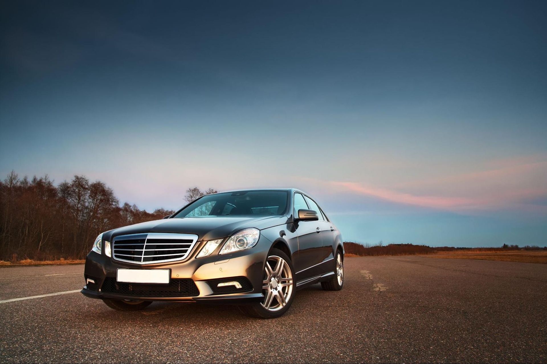 A mercedes benz is parked on the side of the road.