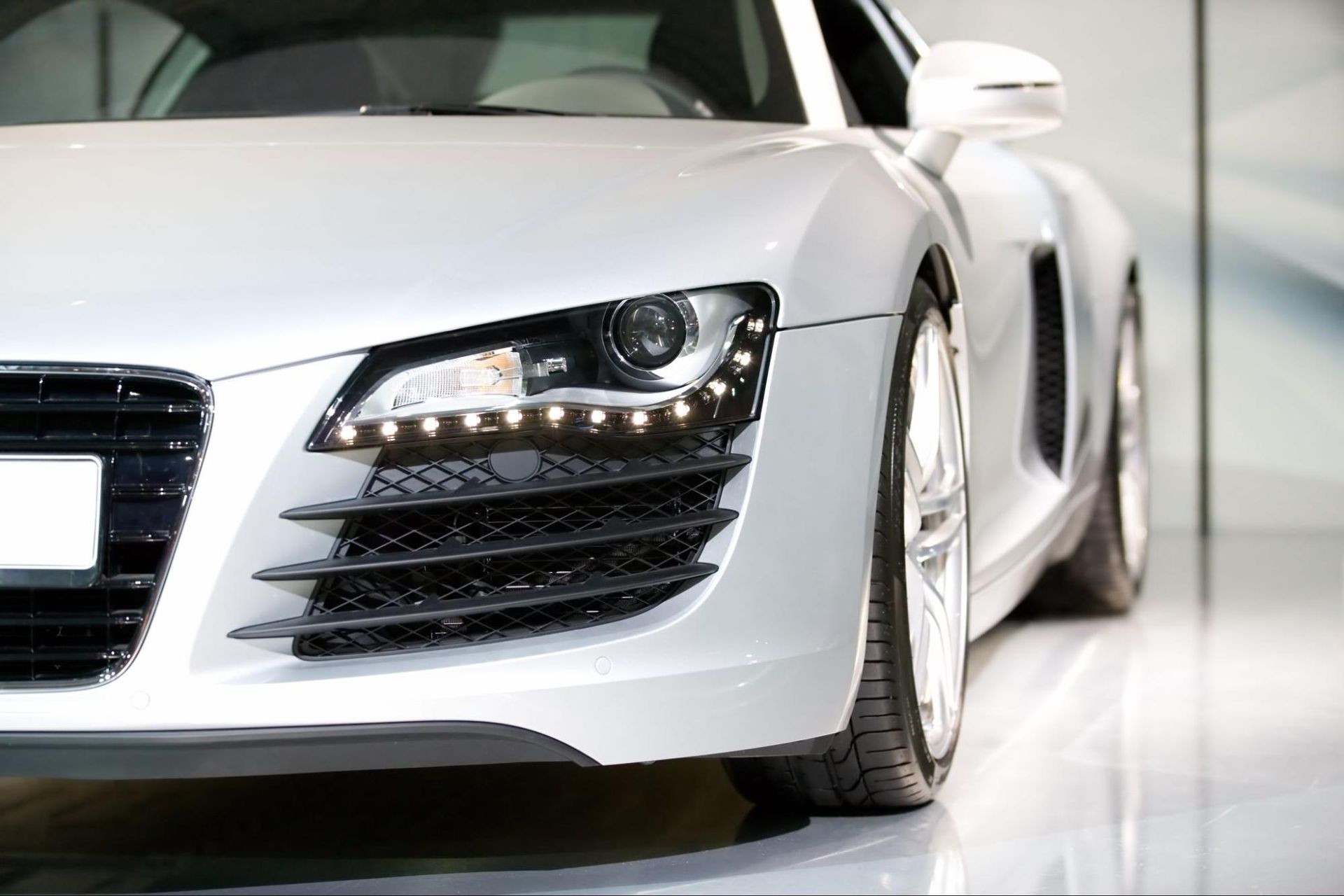 A white sports car is parked in a showroom