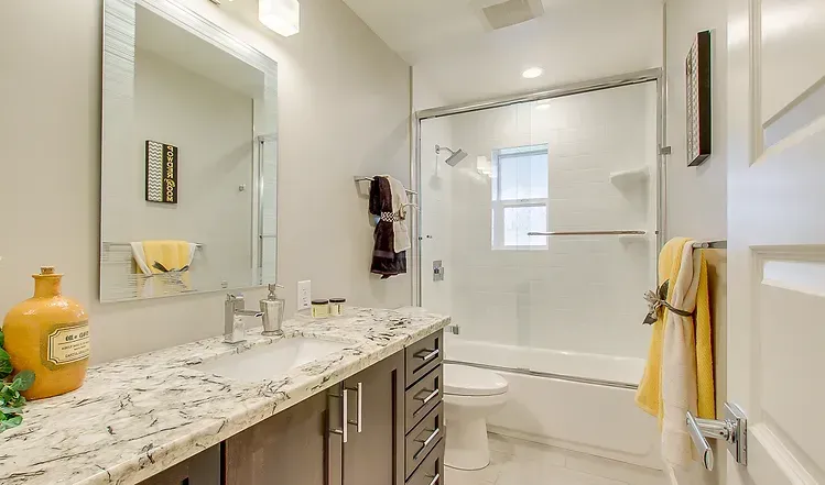 A bathroom with a sink , toilet , tub and mirror.