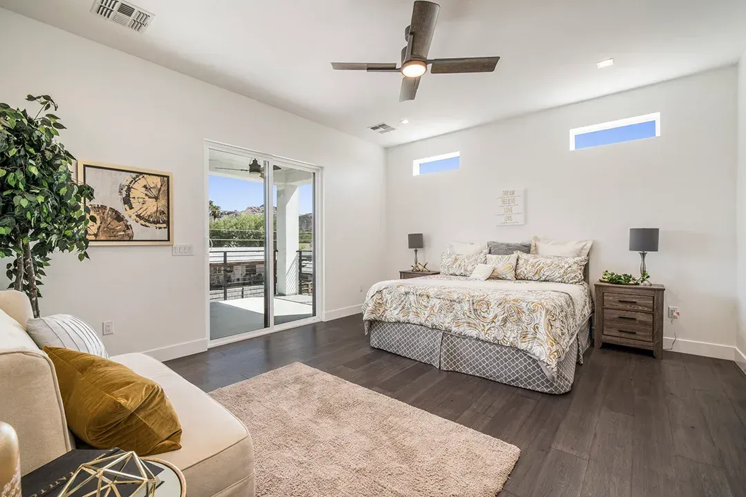 A bedroom with a large bed and a ceiling fan.