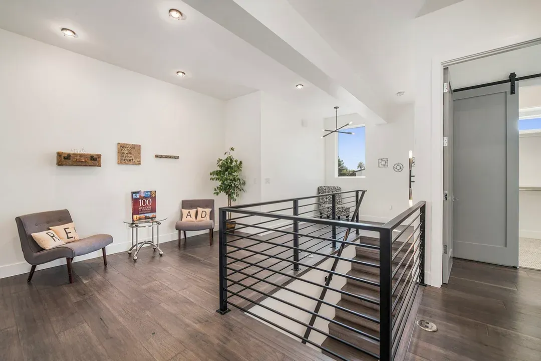 There is a staircase in the middle of the room with a railing.