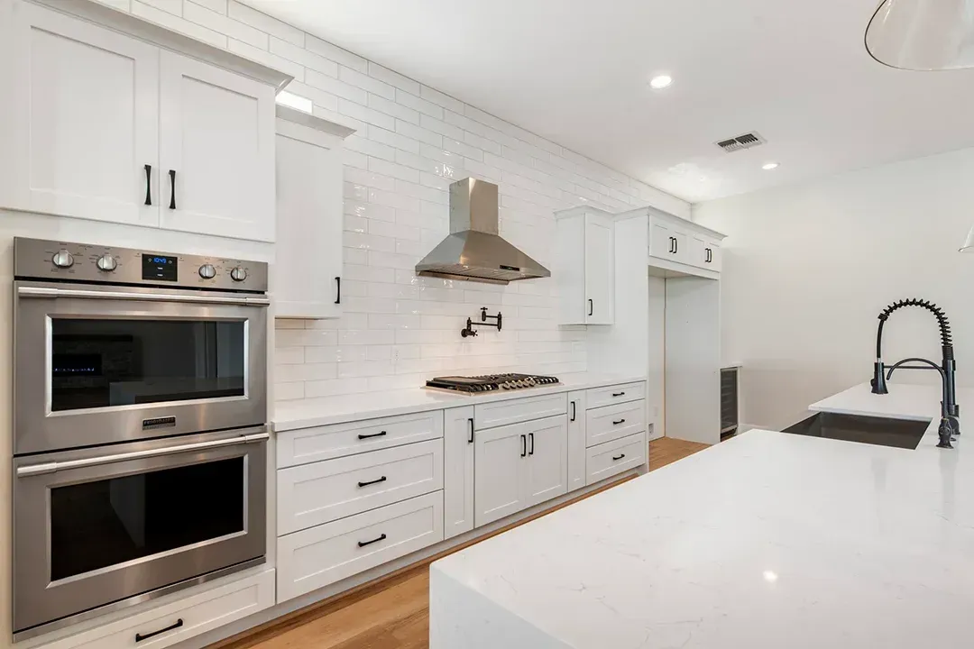 A kitchen with white cabinets and stainless steel appliances