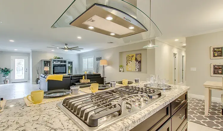 A kitchen with a stove top oven and a hood.