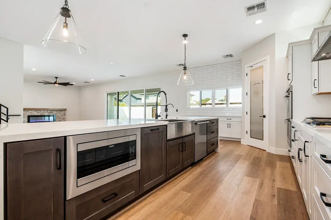 A kitchen with stainless steel appliances and wooden floors.