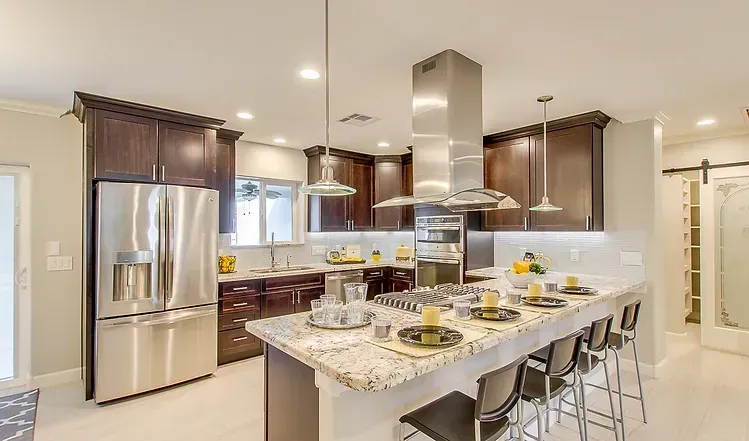 A kitchen with stainless steel appliances and granite counter tops.