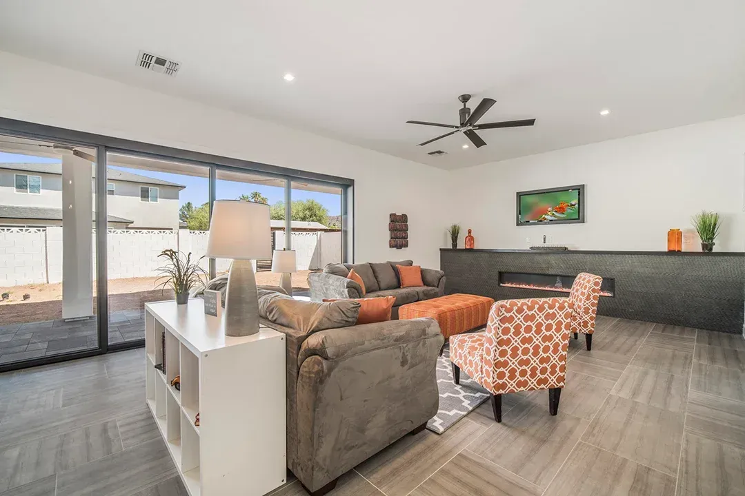 A living room with a couch , chairs , and a ceiling fan.