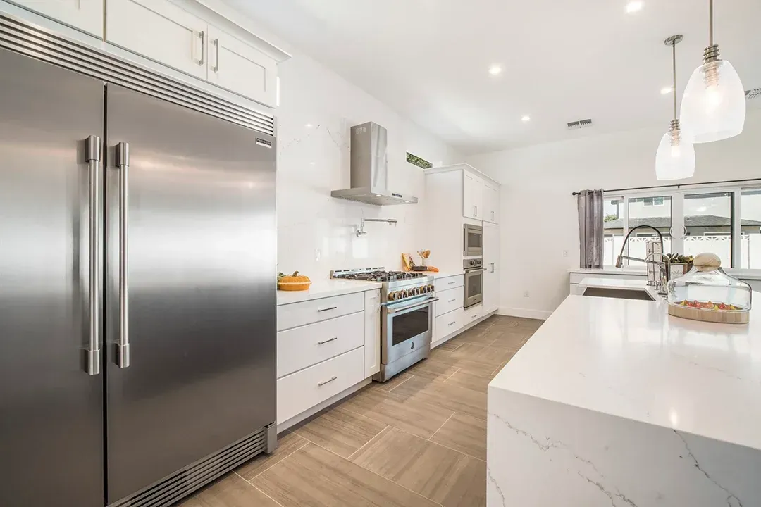 A kitchen with stainless steel appliances and white cabinets.