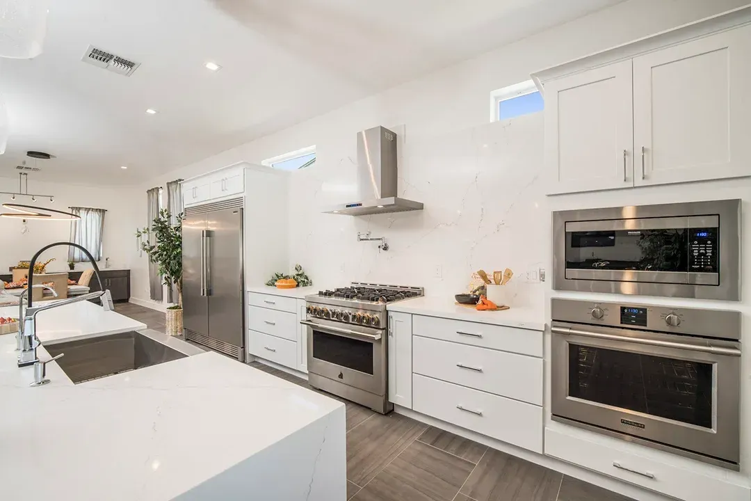 A kitchen with white cabinets and stainless steel appliances.