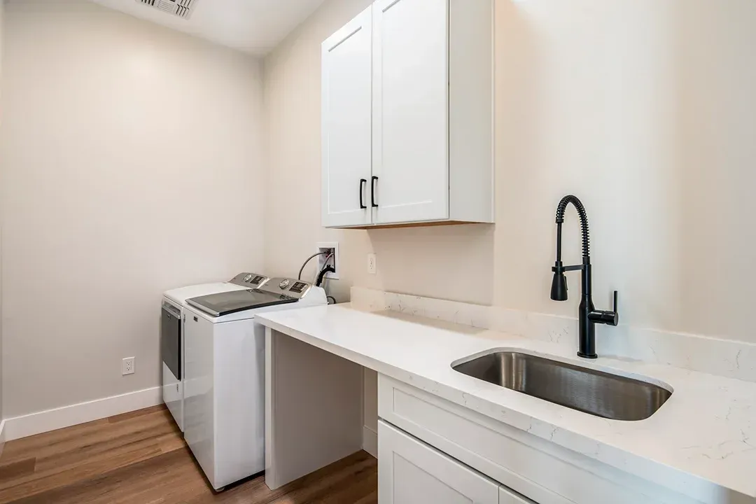 A laundry room with a washer and dryer and a sink.