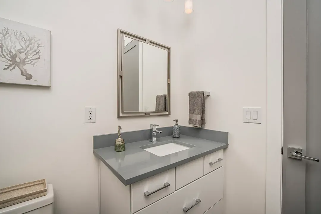 A bathroom with a sink , mirror and toilet.