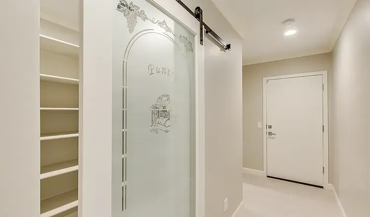 A hallway with a sliding glass door and a white door.