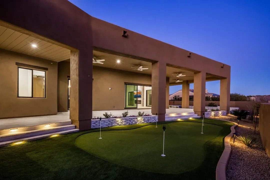 A house with a putting green in front of it