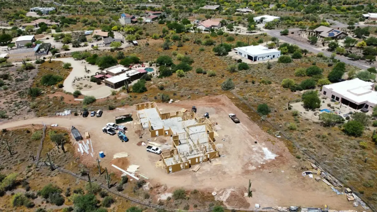 An aerial view of a house under construction in the middle of a desert.