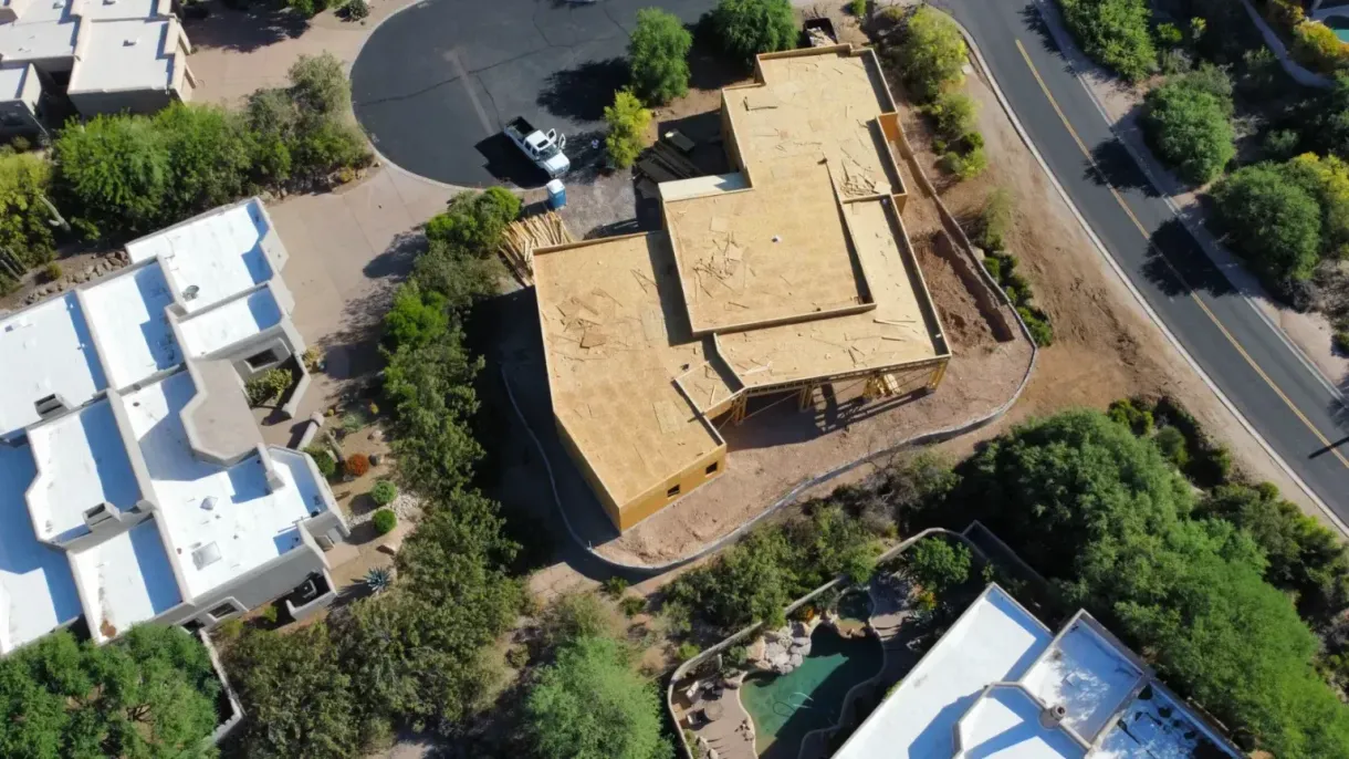 An aerial view of a house under construction in a residential area.