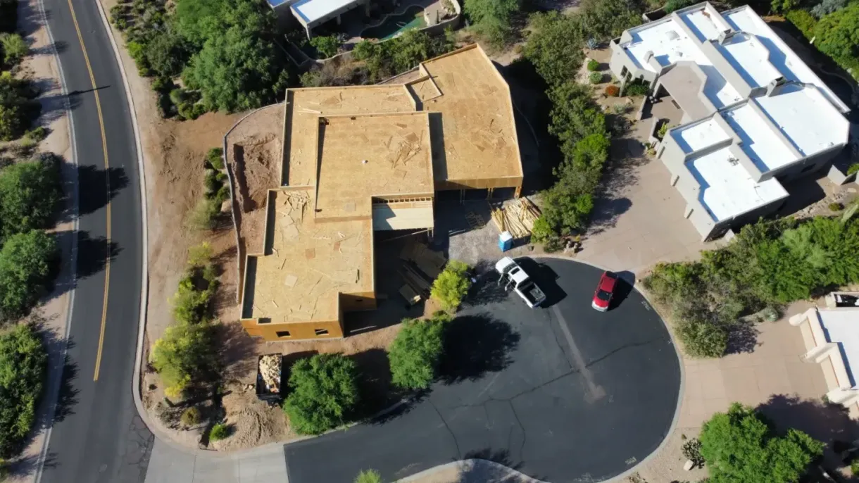 An aerial view of a house with cars parked in front of it.