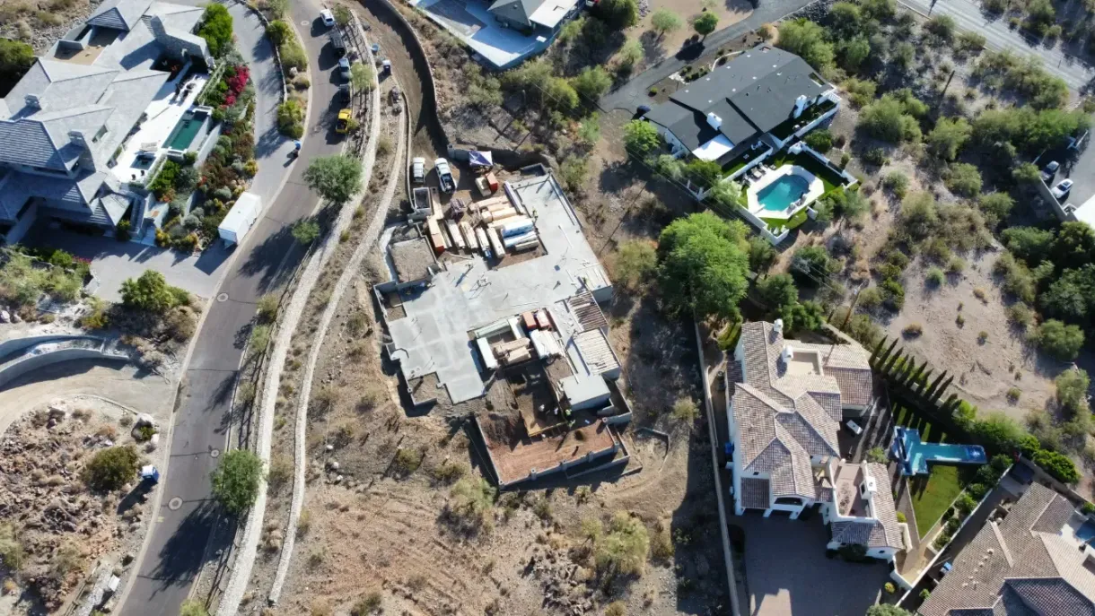 An aerial view of a residential area with houses and a pool.