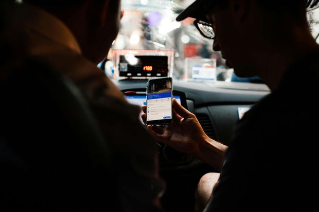 Passenger holding a smartphone in a car, viewing a map app at night