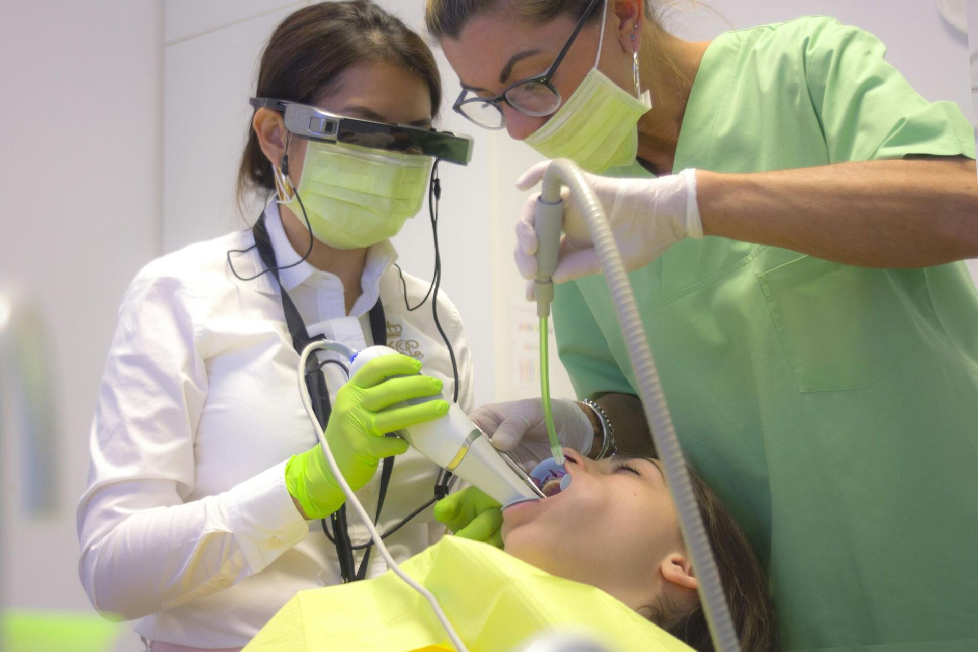 A dentist is examining a patient 's teeth in a dental office.