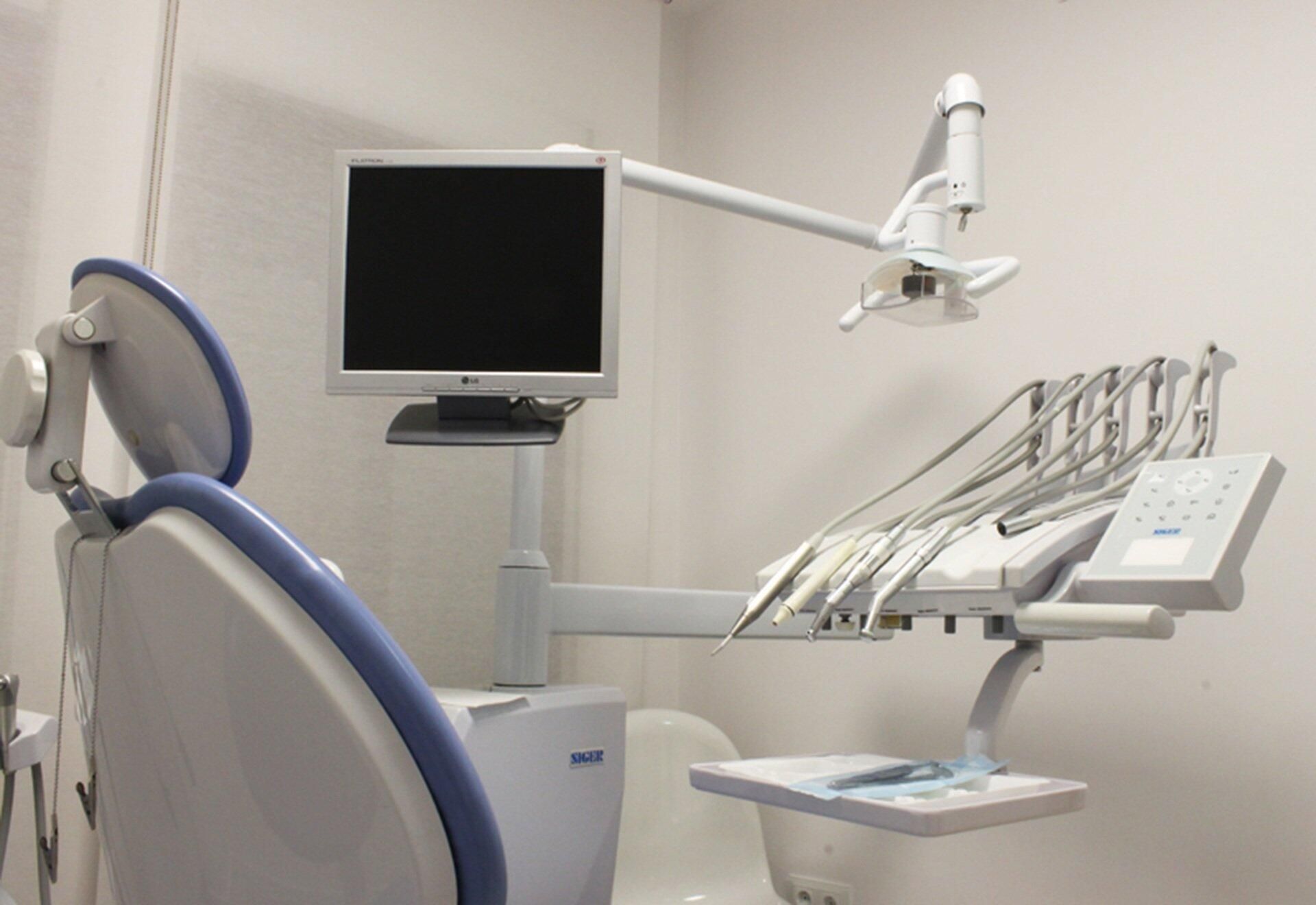 A dental chair with a monitor on top of it