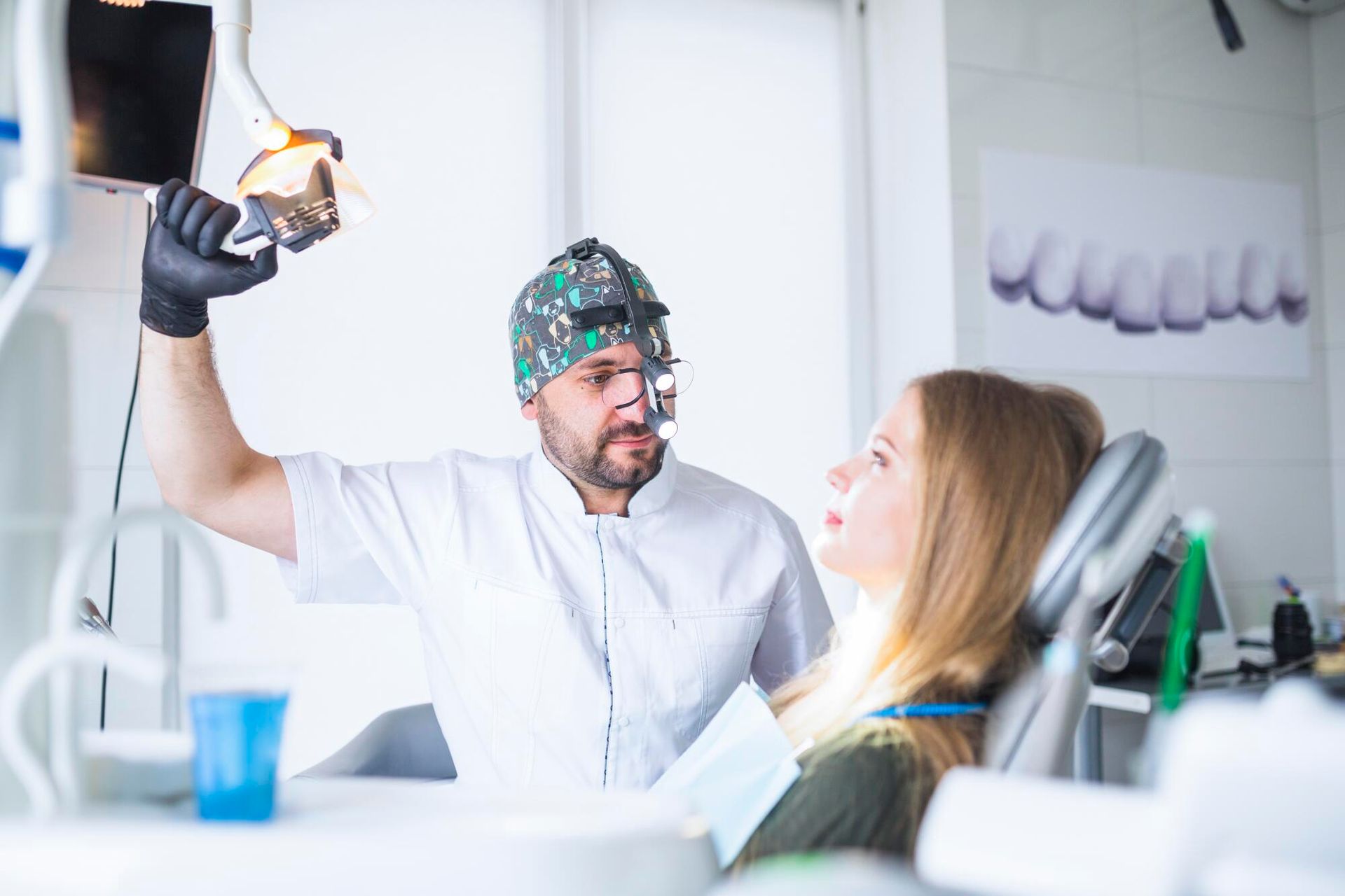 A dentist is examining a patient 's teeth in a dental office.