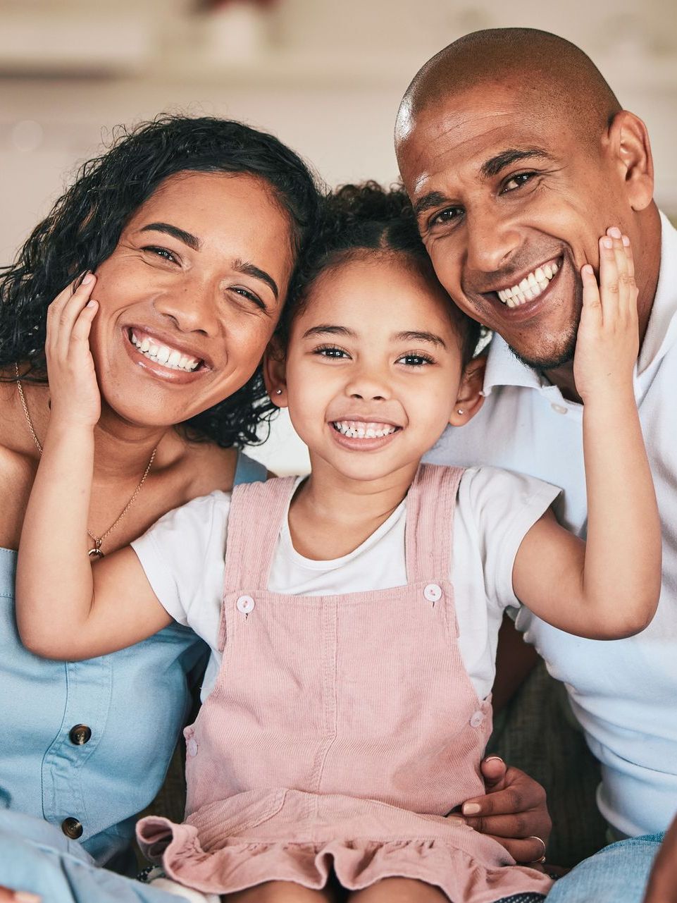 A family is posing for a picture together while sitting on a couch.