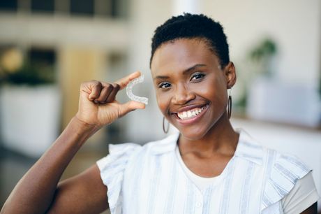 Black woman holding invisalign